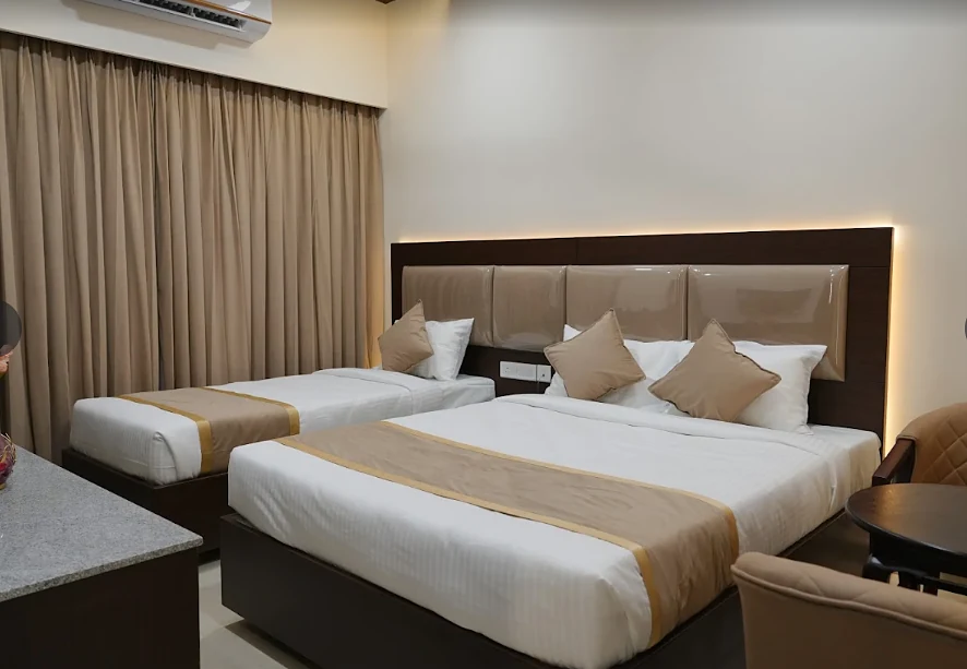 Deluxe Triple room, beds and TV wall