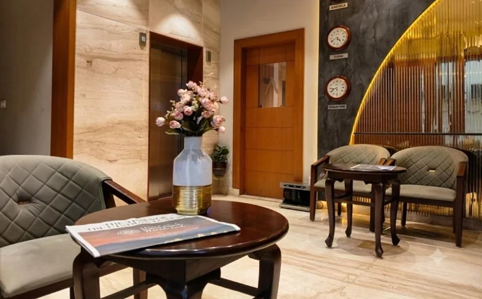 Lobby seating with flowers, a round table and the world clocks